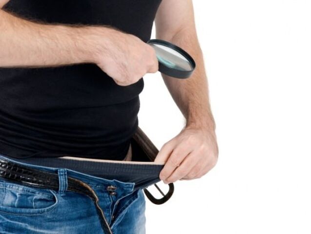 Ein Mann blickt in seine Hose und möchte seinen Penis vergrößern